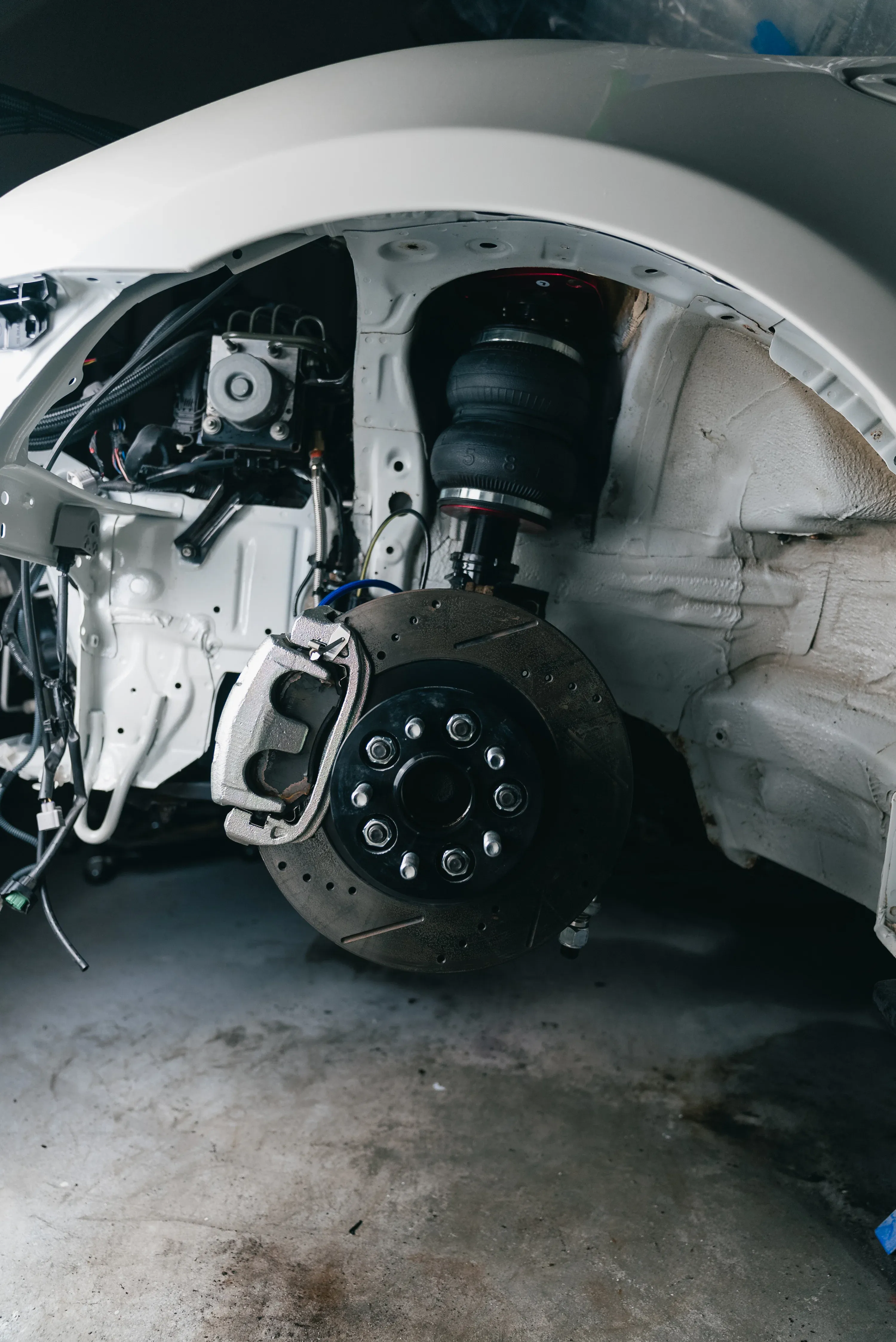 Exposed front wheel hub, brake rotor and suspension components during workshop inspection