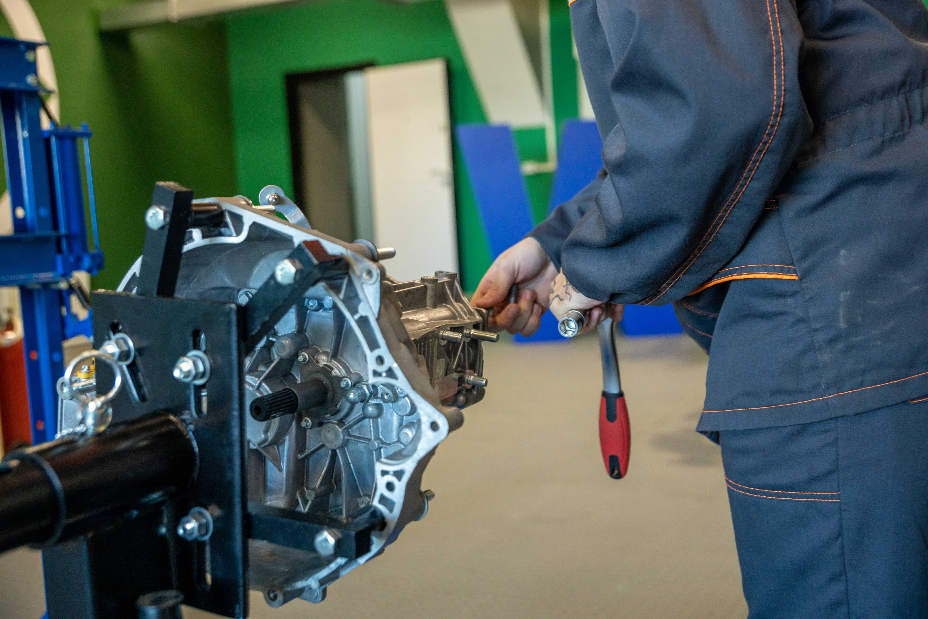 Mechanic inspecting an automatic transmission on a workshop bench
