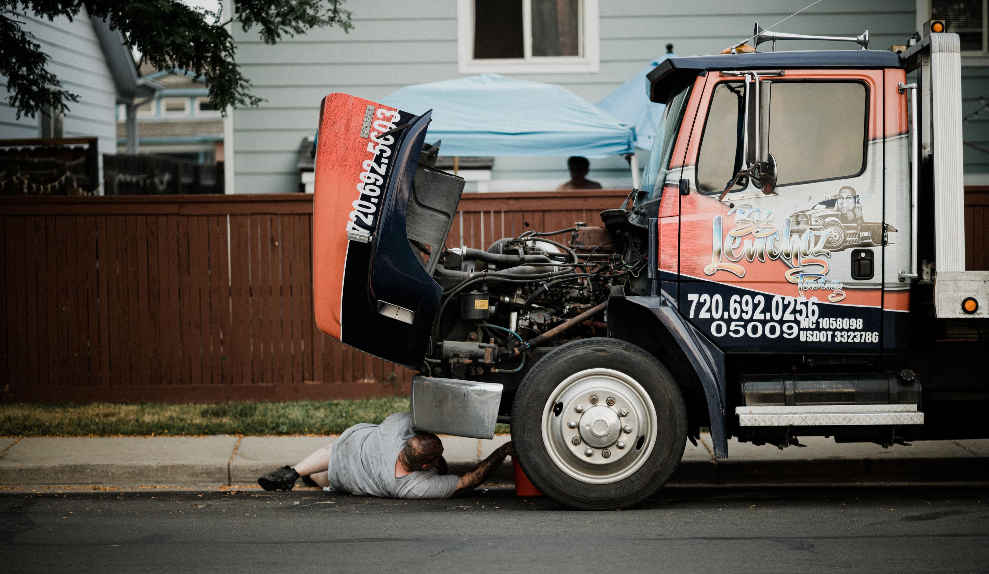 Mechanic inspecting the underside and rear axle area of a pickup truck