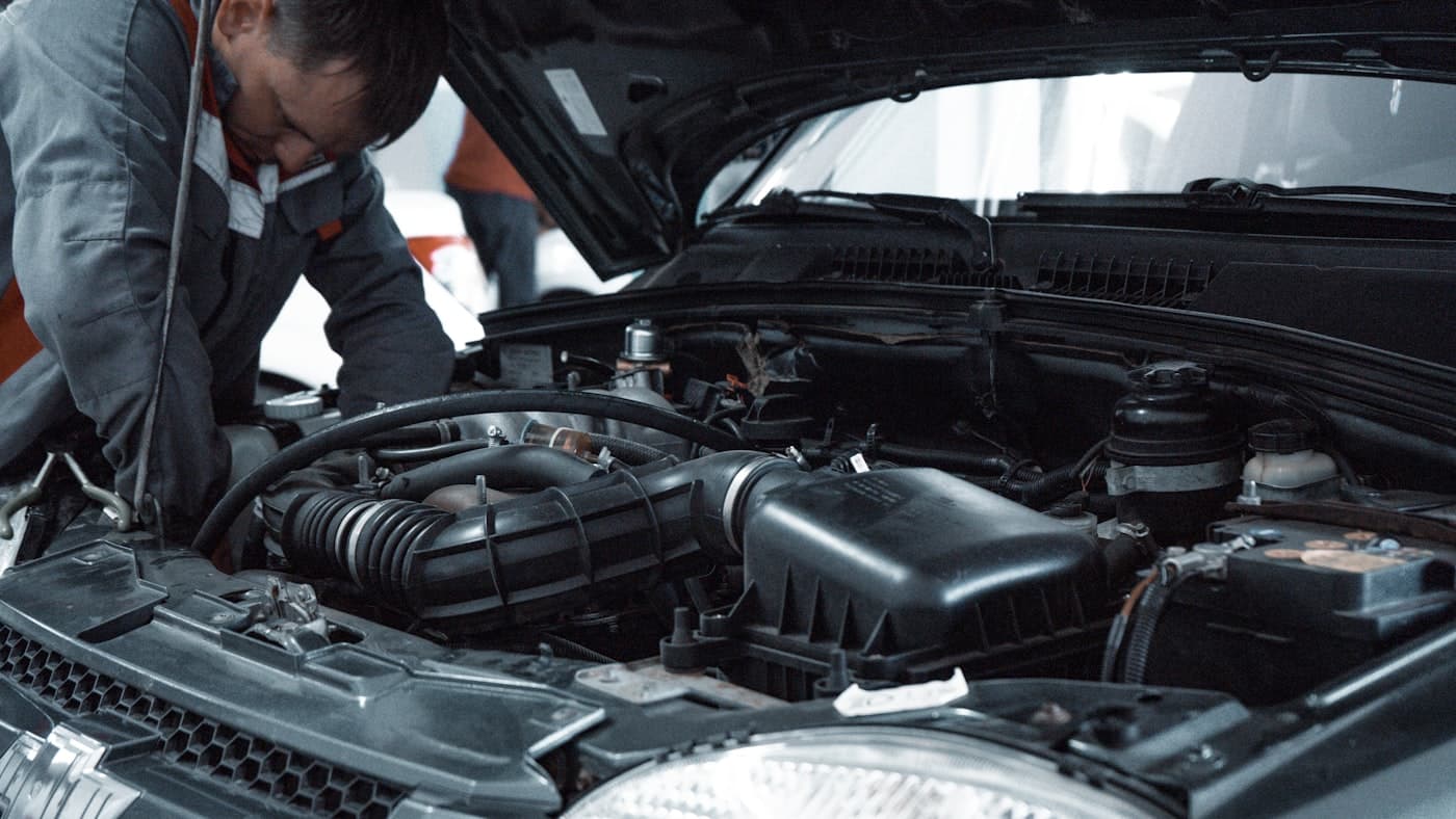 Technician inspecting an engine in a service bay